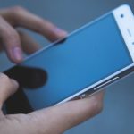 Mains sur un téléphone portable à nettoyer