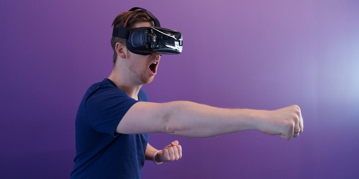 homme donnant un coup de poing avec un casque de realité virtuelle