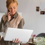 Les outils essentiels à maîtriser pour exceller en tant qu’assistant marketing Femme assistante marketing qui tien un téléphone et un ordinateur blanc